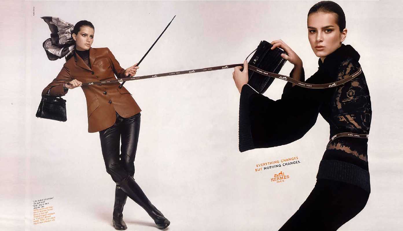 Two women in leather outfits with accessories on a white background