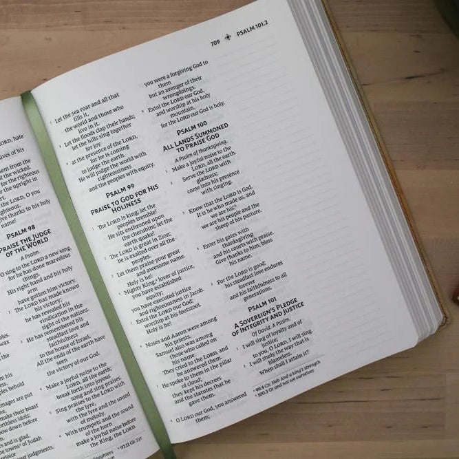Open bible with text on a wooden surface