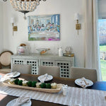 Dining room with a table set for four, decorative items, and a painting on the wall.