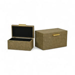 Two gold storage boxes with black interiors on a white background
