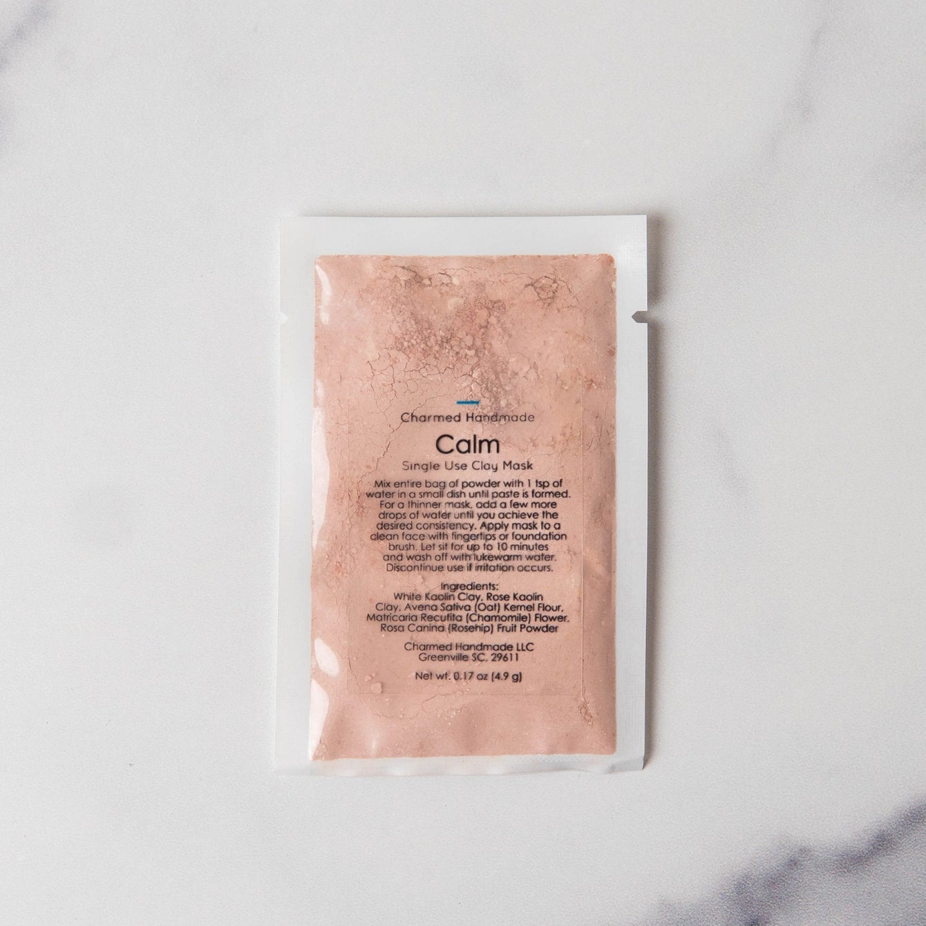 Pink skincare mask packet on a marble background