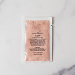 Pink skincare mask packet on a marble background
