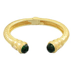 Gold bracelet with green gemstones on a white background