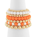 Set of colorful beaded bracelets on a white candle