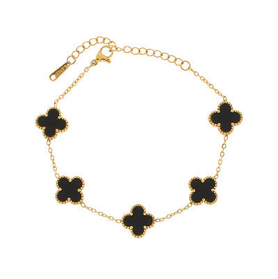 gold chain bracelet with five clover-shaped black enamel charms