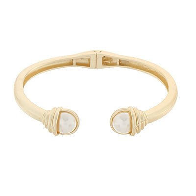 gold hinged cuff bracelet with two pearl like ends accented by wrapped gold detail