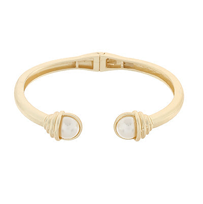 gold hinged cuff bracelet with two pearl like ends accented by wrapped gold detail
