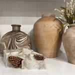 Decorative vases and a crystal bowl on a white surface with a neutral background
