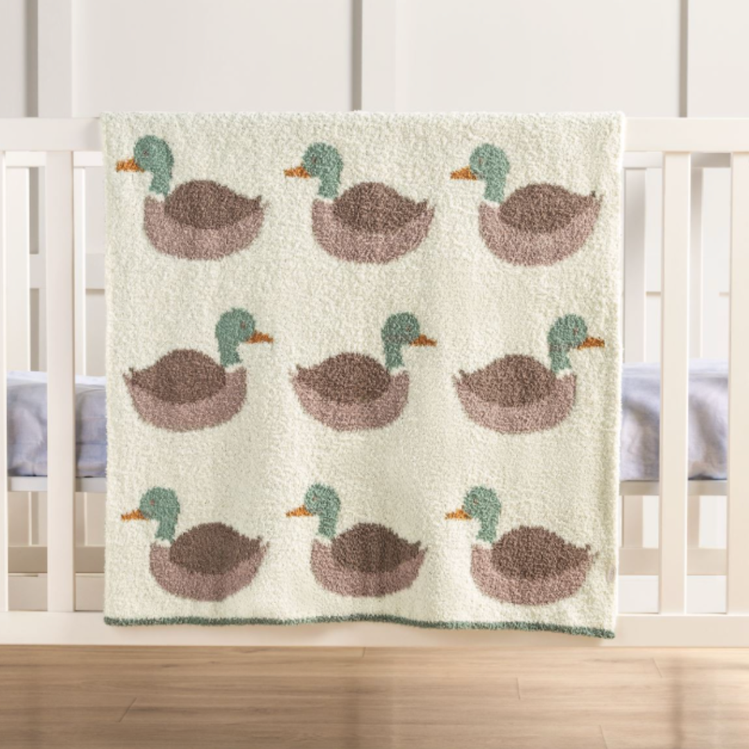 chenille blanket with mallard ducks hanging on a baby crib