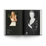 An open book or photo album spread on a white background, showing two printed portrait photographs of the same woman on the left and right pages. The left page has a color photo in a white dress, and the right page has a black-and-white portrait in a dark outfit.