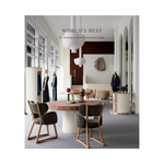 A book cover titled 'WORLD'S BEST 50 Boutiques from around the Globe' featuring a photograph of a modern, stylish boutique interior with wooden chairs, a round table, and mannequins displaying clothing.