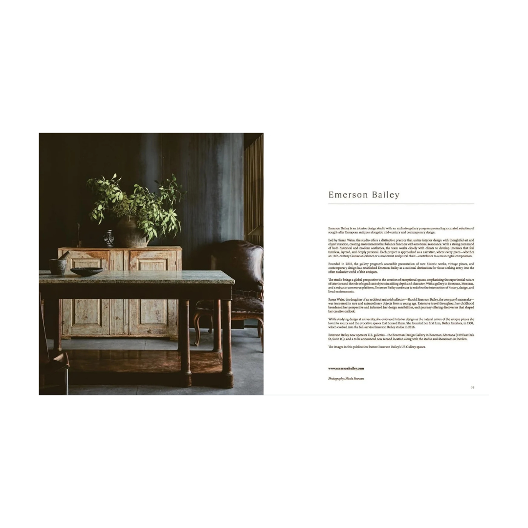 An open book view of interior design spread with a dark, moody room scene on the left showing a rustic wooden sideboard and table with plants, and a text column on the right headed Emerson Bailey.