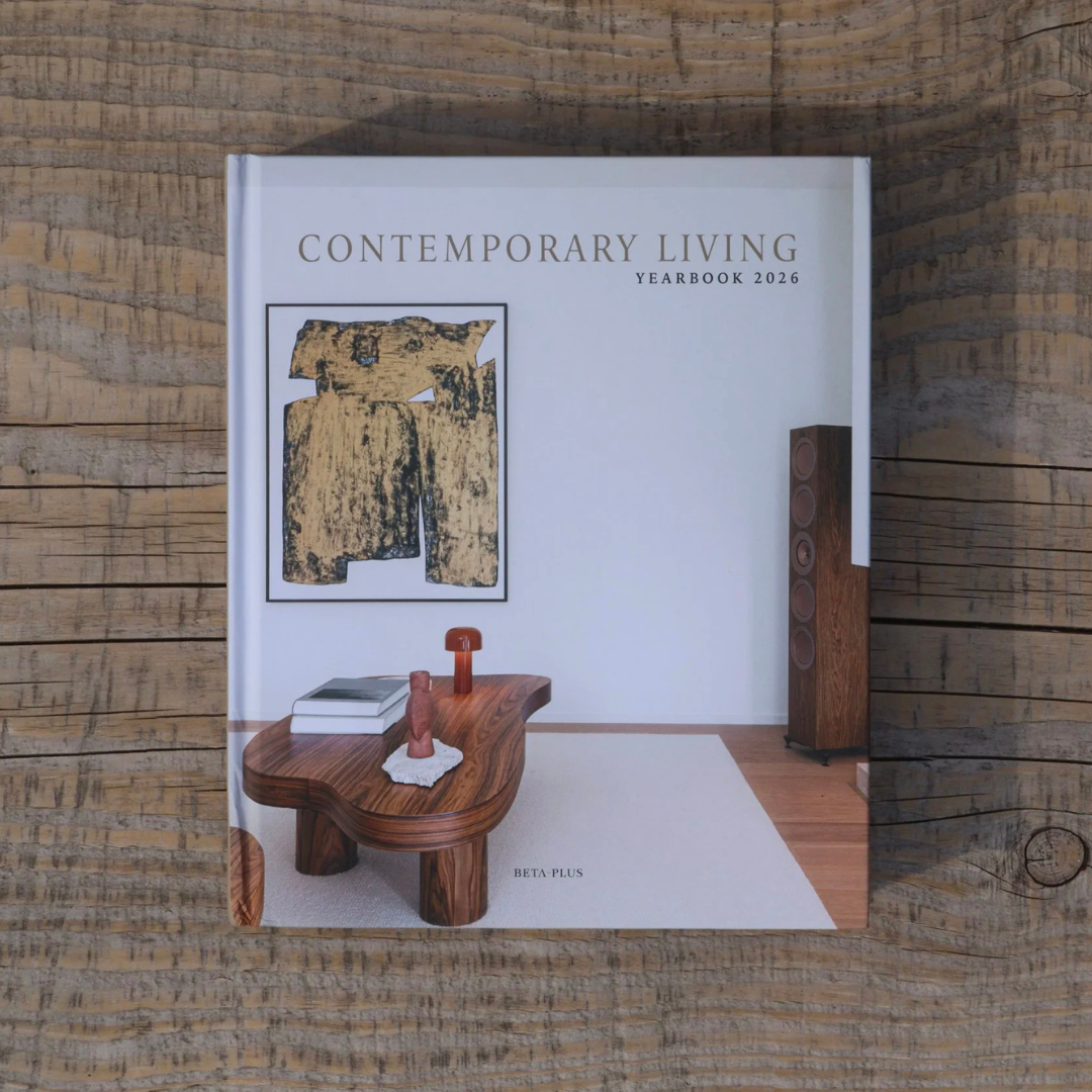 A hardcover book titled 'Contemporary Living Yearbook 2026' by Ben Plain, featuring a modern living room interior cover design, photographed flat on a rustic wooden surface.