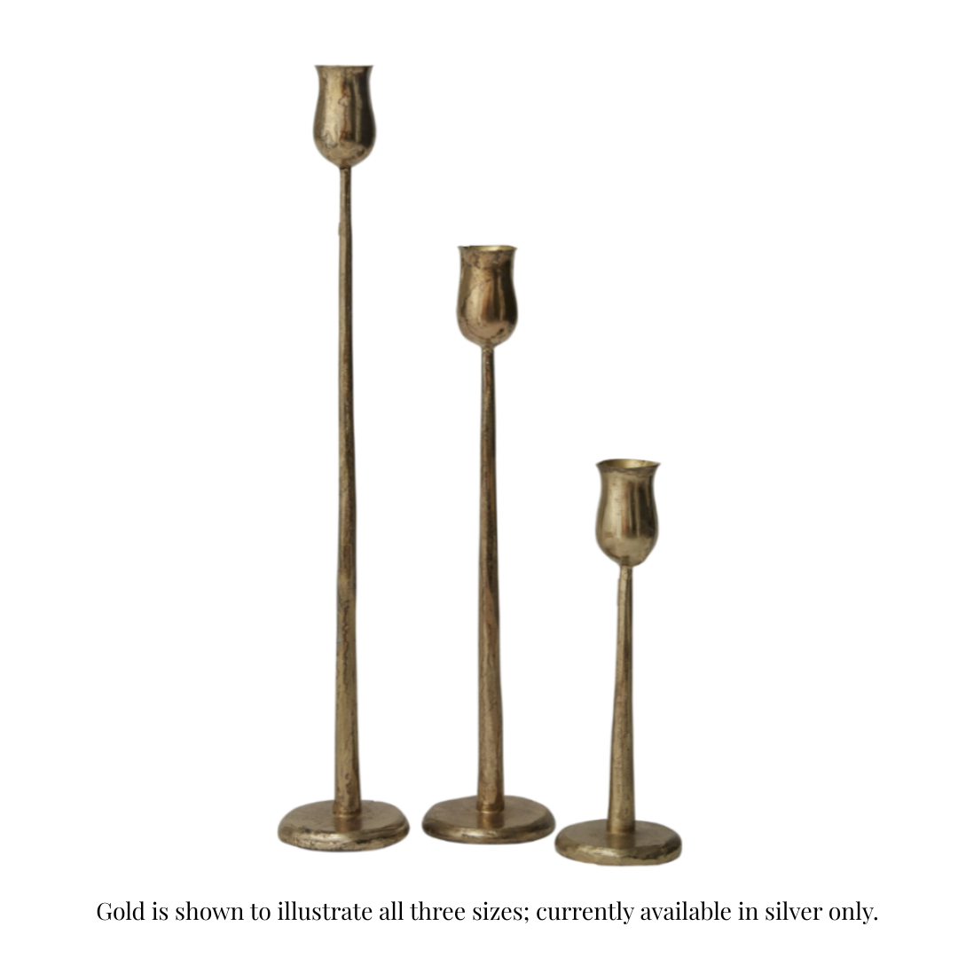 Three brass candlesticks of different heights with a textured metallic finish, arranged in a row against a plain white background.