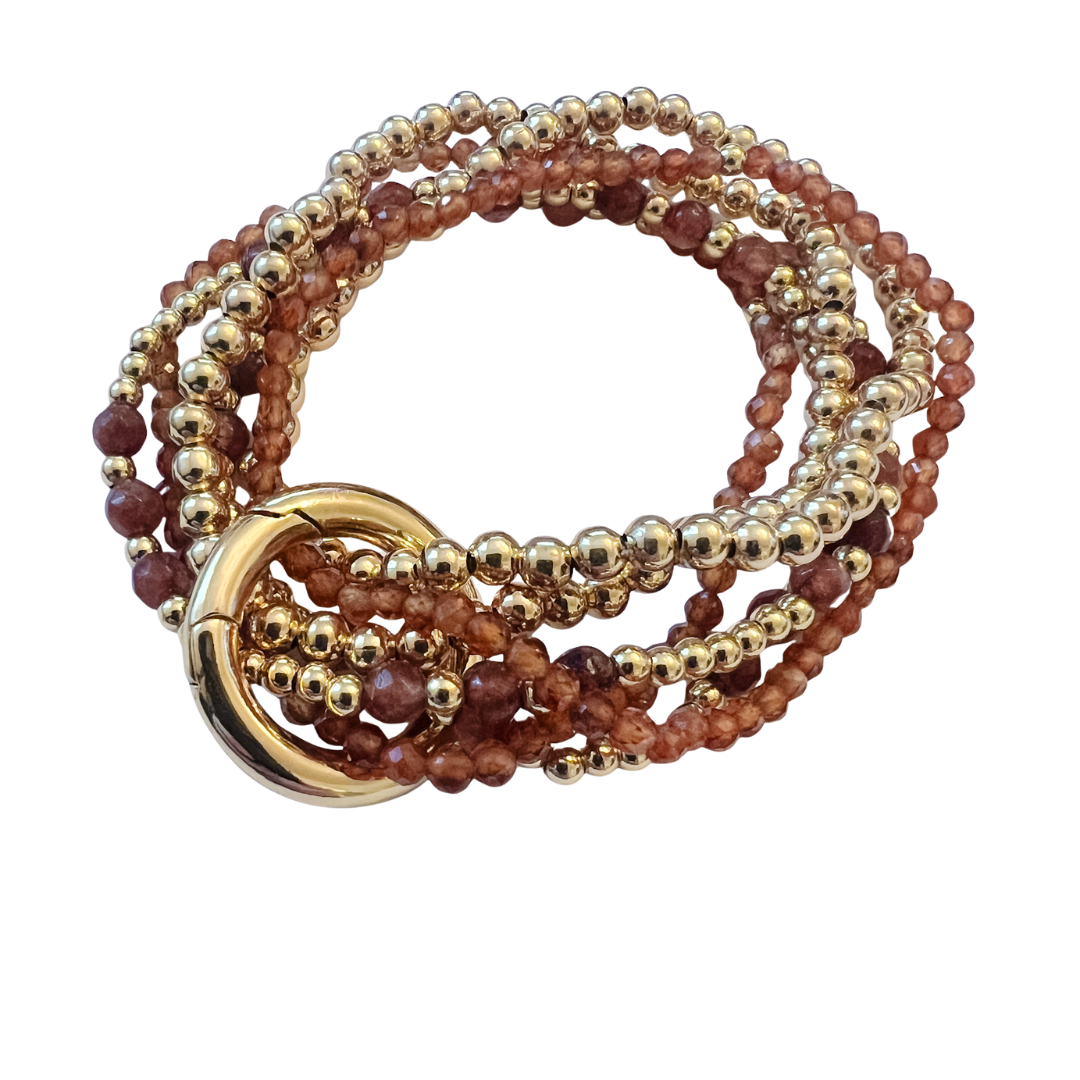 Beaded bracelet with faceted carob-colored stone beads, polished gold beads, and gold clasp, shown worn alone and styled with a gold heart charm