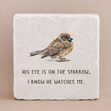 Decorative stone with engraved text "His eye is on the sparrow, i know he watches me" and an image of a bird on a beige background