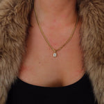 Woman wearing sunglasses, fur coat, and black top against a white background
