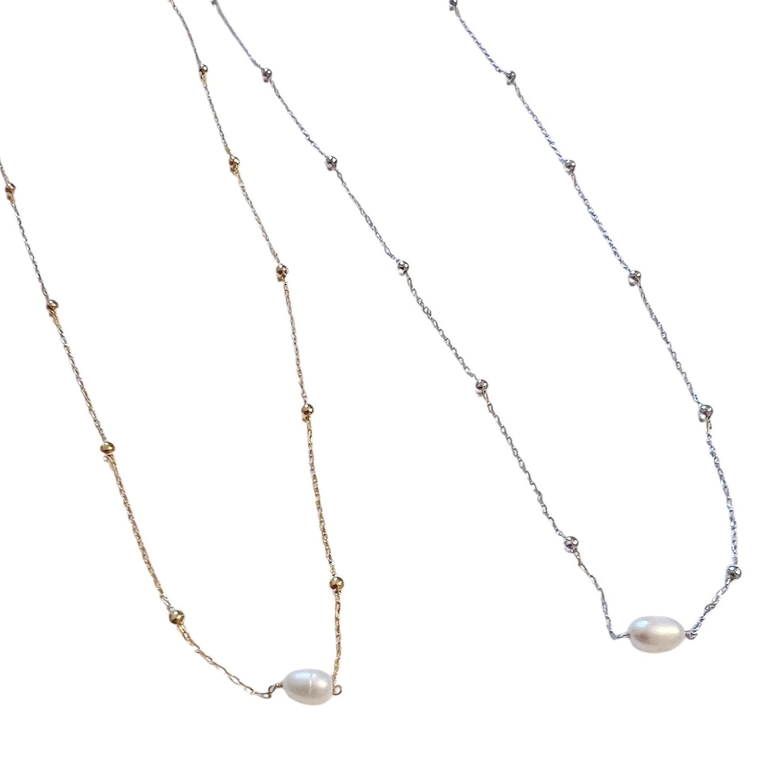 Two delicate necklaces, one in gold and one in silver, each featuring a single freshwater pearl pendant and beaded accents on the chain, displayed on a white backgroun