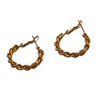 A pair of gold twisted hoop earrings with a rope-like design and latch-back closures, displayed against a white background.