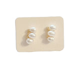 dainty earrings feature three lustrous pearls arranged in a sleek bar design,