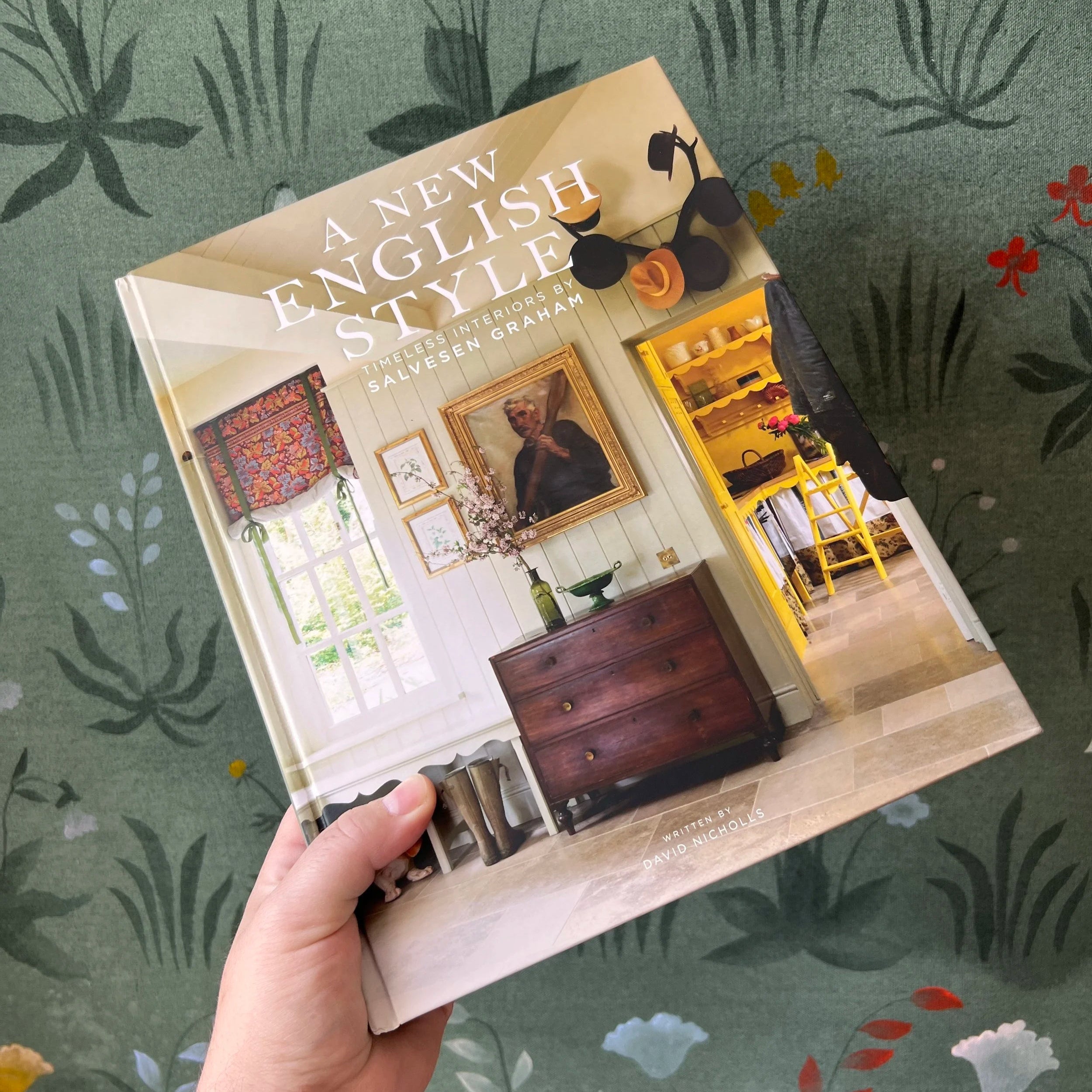 Book titled 'A New English Style' held against a floral-patterned background