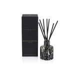 Aromatherapy diffuser with black sticks and a black box labeled 'Black Fig Vetiver' on a white background.