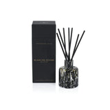 Aromatherapy diffuser with black sticks and a black box labeled 'Black Fig Vetiver' on a white background.