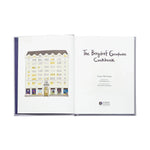 Open book titled 'The Bergdorf Goodman Cookbook' with a building illustration on the cover.