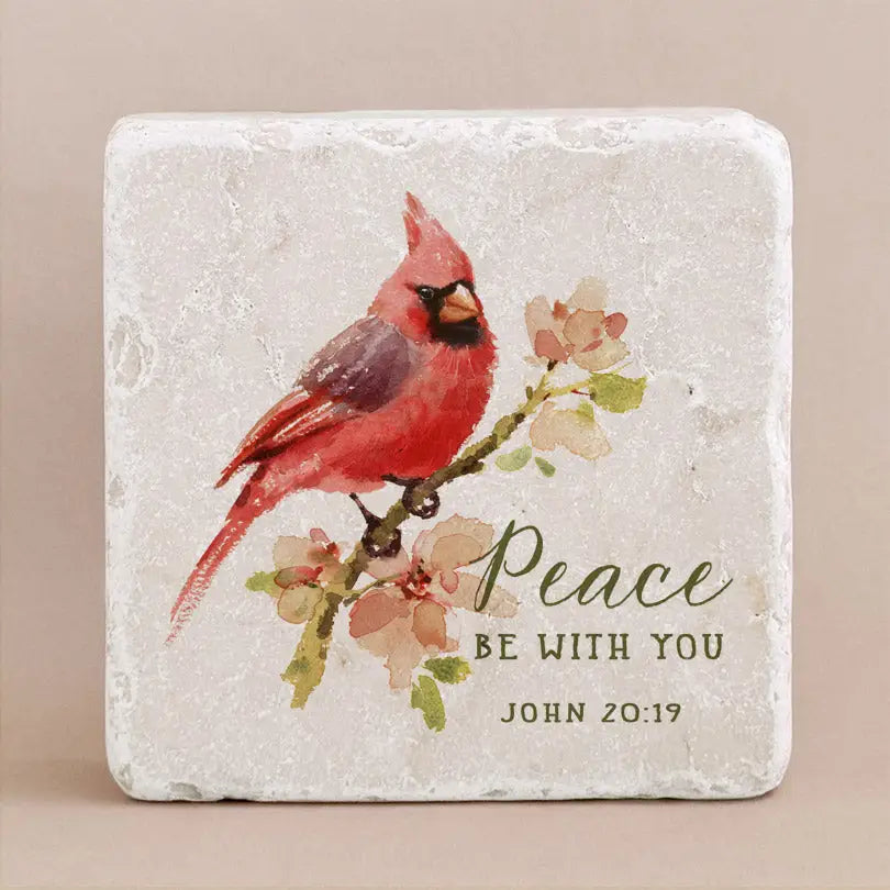 Decorative stone with engraved text from John 20:19 with a cardinal on a beige background