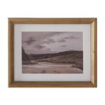 Framed artwork of a landscape with mountains and water.