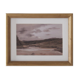Framed artwork of a landscape with mountains and water.