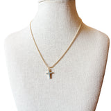 Liana Necklace features a gold beaded chain and a cross charm accented with subtle blue details. 