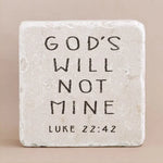 Decorative stone with engraved text from Luke 22:42 on a beige background