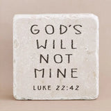 Decorative stone with engraved text from Luke 22:42 on a beige background