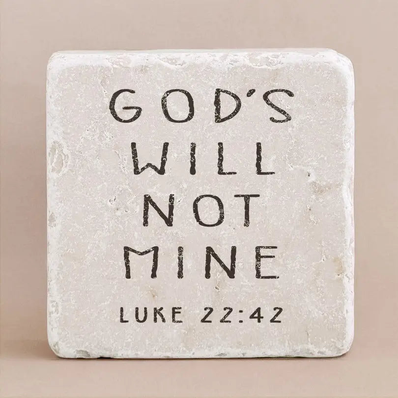 Decorative stone with engraved text from Luke 22:42 on a beige background