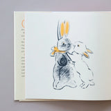 Illustration of two bunnies on a book page with text on a gray background