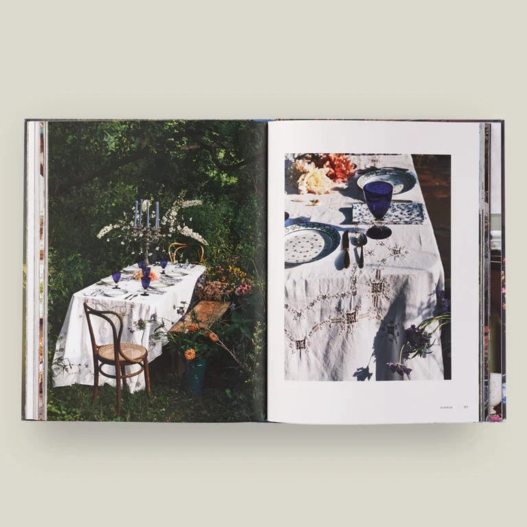 Open book showing images of a table setting outdoors with chairs.