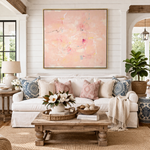 Living room with a white sofa, decorative pillows, a wooden coffee table, and abstract art on the wall.
