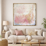 Living room with a beige sofa, abstract painting, and decorative items.