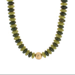 Necklace with green and gold beads on a white background