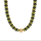 Necklace with green and gold beads on a white background