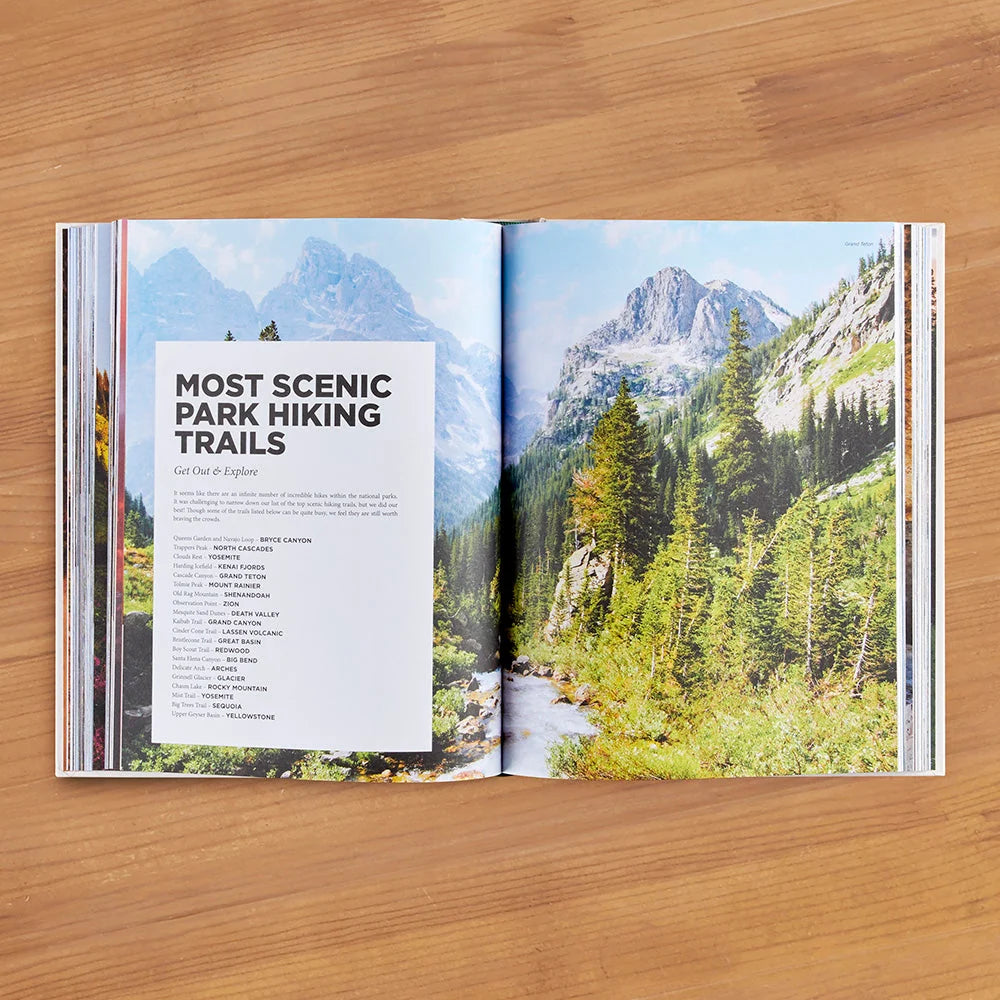 open book showing a view of mountain side with text on most scenic park hiking trails from hardcover book "Roaming America" laying on hardwood floor