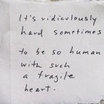 Text on a film strip background reading 'It's ridiculously hard sometimes to be so human with such a fragile heart.'