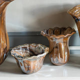 Three onda glass vases with marbled brown and beige design on a reflective surface.