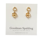 gold flower charms suspended from classic circular studs.