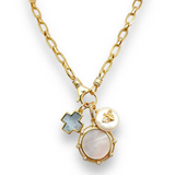 Gold necklace with various charms on a white background