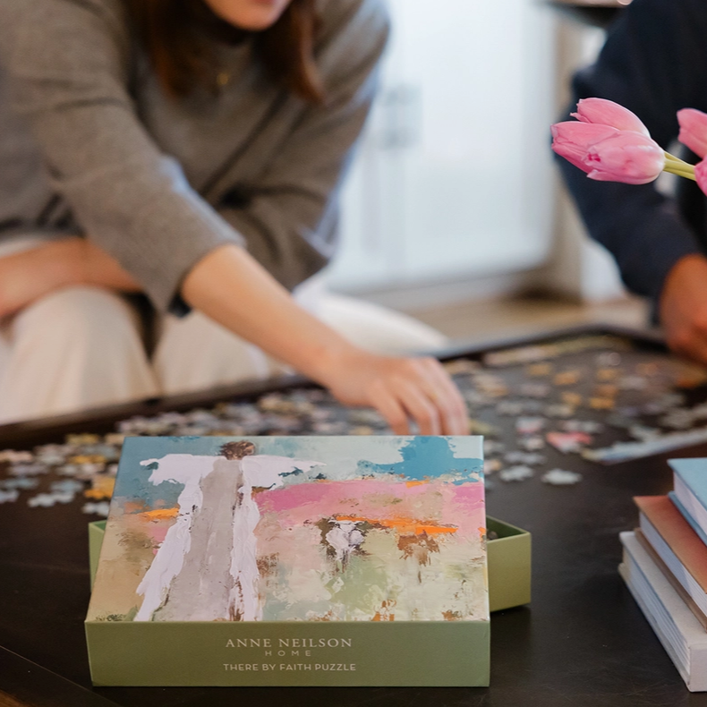 Two people working on a puzzle with a decorative box in the foreground