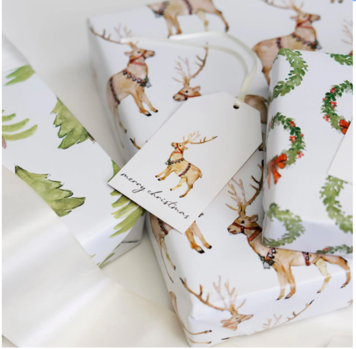 Roll of Christmas-themed wrapping paper with deer and wreath designs on a white background.