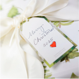 Gift wrapped in green paper with a white ribbon and a 'Merry Christmas 2025' tag.