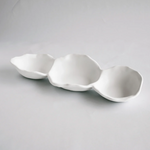 Three white ceramic bowls of varying sizes on a gray background